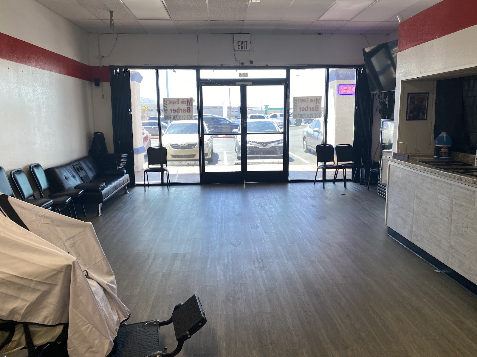 Interior of the barbershop with waiting-area seating and the front entrance