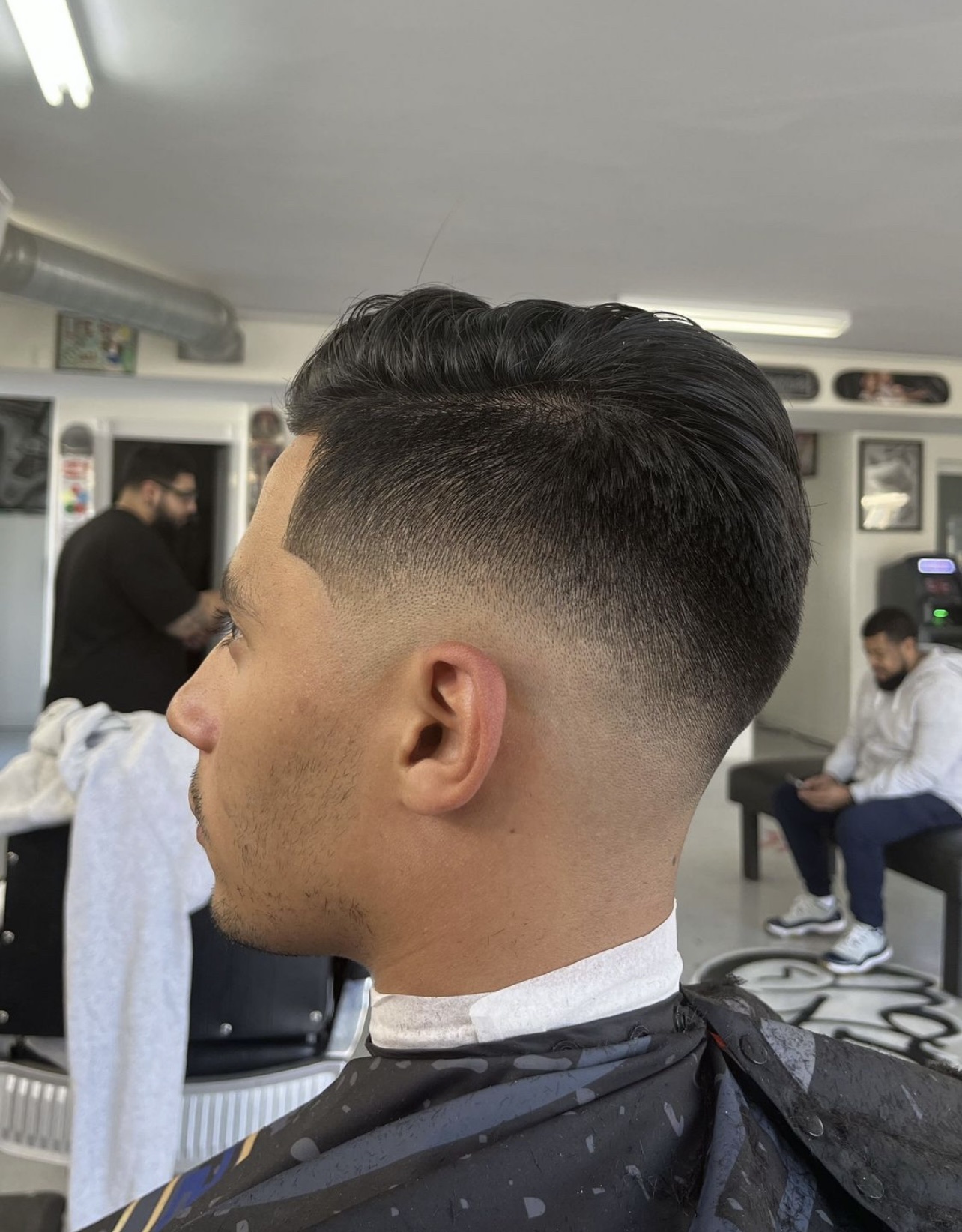 Man with a textured top and skin fade haircut in the barbershop